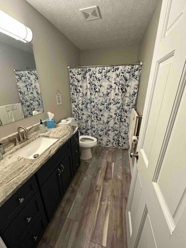 ein Badezimmer mit einem Waschbecken, einem WC und einem Spiegel in der Unterkunft Wander & Stay Getaway in Logan
