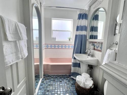 een badkamer met een roze bad en een wastafel bij Beautiful Colorado Home, Centrally Located! Great Yard! in Wheat Ridge