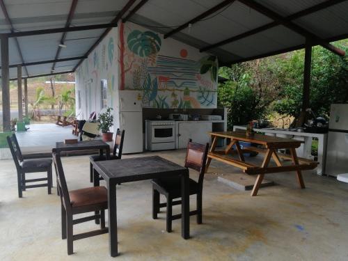 Il dispose d'une cuisine et d'une terrasse avec des tables et des chaises. dans l'établissement Tortuga Hostal, à Pedregal