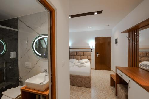 W łazience znajduje się umywalka, toaleta i prysznic. w obiekcie Hotel Meta Ksamil w mieście Ksamil