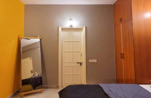 a bedroom with a mirror and a bed and a door at Pearl - Sunflower Skyline in Bangalore