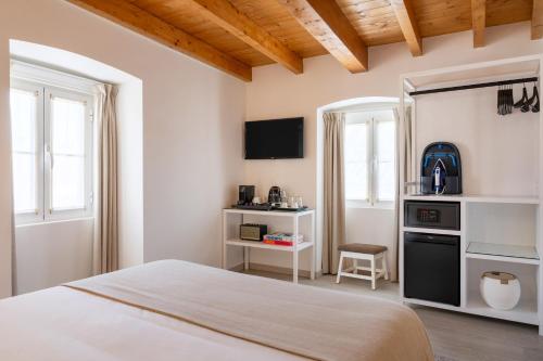 a bedroom with a bed and a desk with a microwave at Azinheira Suites Townhouse - Alojamento Turístico in Elvas