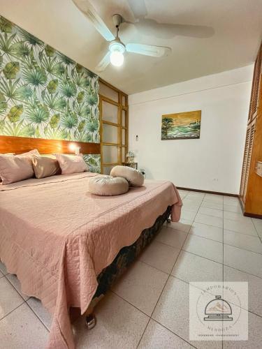 a bedroom with a large bed with a pink blanket at Departamento Plaza Independencia con terraza, kilometro cero Mendoza in Mendoza