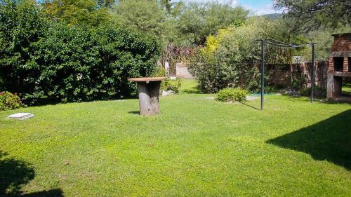 un banco de piedra sentado en medio de un patio en Cabañas LA ILUSION en La Puerta