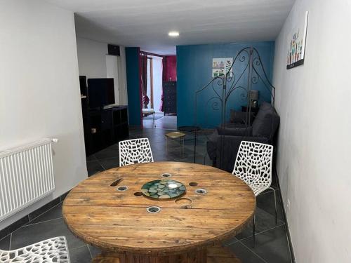 a dining room with a wooden table and chairs at Logement du Paquis in Les Mazures
