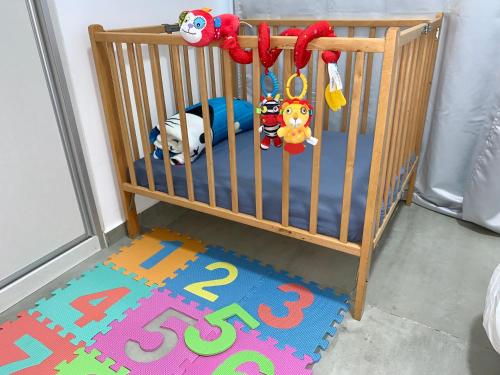 a crib with toys and a rug in a room at Midtown Tel Aviv Luxury Apartment in Tel Aviv