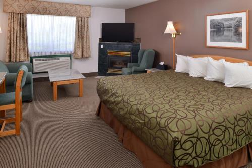 a hotel room with a bed and a living room at Canadas Best Value Inn Valemount in Valemount