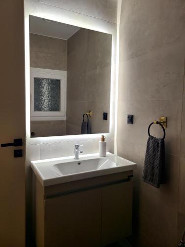 a bathroom with a sink and a mirror at An Oasis By The Beach in Kiáton