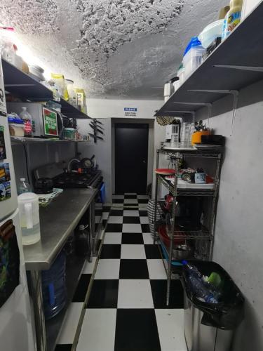 a kitchen with a black and white checkered floor at 777 LENDERMAN HoSTaL 777 in Cancún