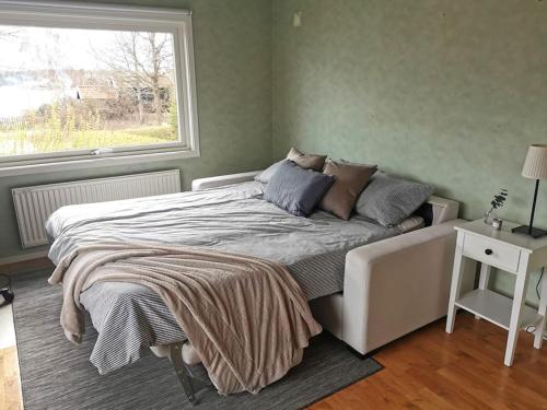 um quarto com uma cama grande e uma janela em Gästhus nära havet em Kalmar