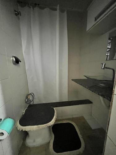 uma casa de banho com um WC preto e branco e um lavatório. em Não façam a reserva , não está disponível , o app não tá deixando tirar mais da página no Rio de Janeiro