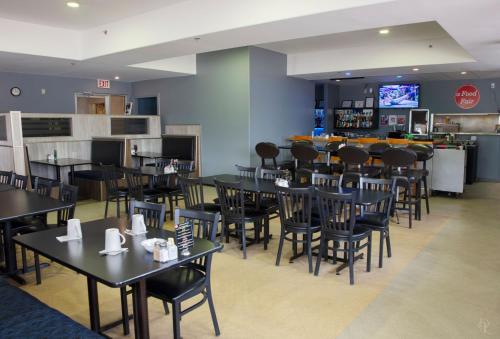 un restaurant avec des tables et des chaises ainsi qu'un bar dans l'établissement All Stay Suites, à Westlock