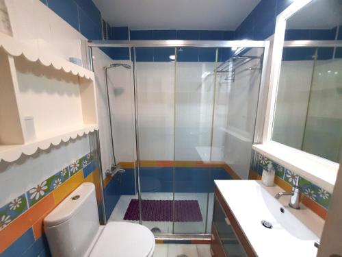 y baño con ducha, aseo y lavamanos. en Amplio apartamento en La Barrosa, en Novo Sancti Petri