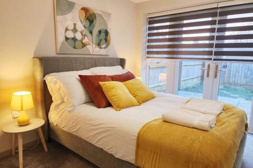 a bedroom with a bed with pillows and a window at Horizon House, Luxury 2-Bedroom Flat 3 in Oxford