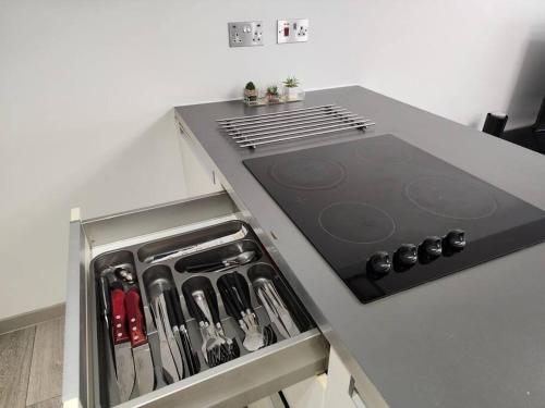 a kitchen with a stove top with a drawer at Horizon House, Luxury 2-Bedroom Ground floor flat, Parking, WiFi, Netflix in Oxford