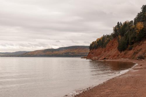 a view of a body of water with trees and mountains at Chalet La Renarde in Nouvelle