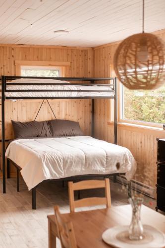 a bedroom with a bunk bed in a wooden wall at Chalet La Renarde in Nouvelle