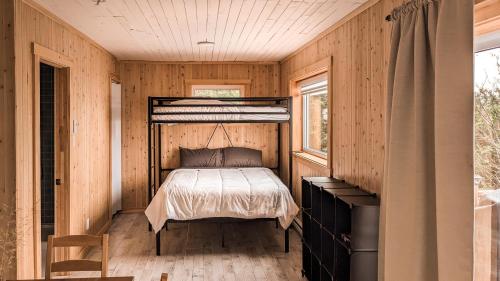 um quarto com uma cama numa parede de madeira em Chalet La Renarde em Nouvelle