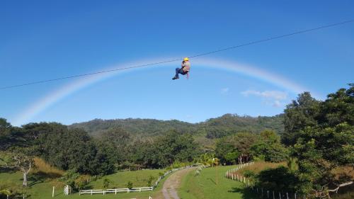 a person is hanging on a zip line at Vida Aventura Ranch in Tanques