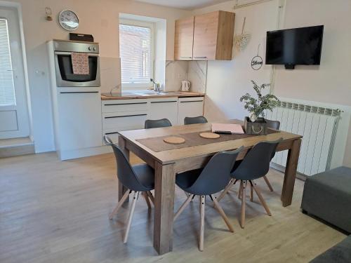 a kitchen with a wooden table and chairs in a room at Apartments Rupnik in Bovec
