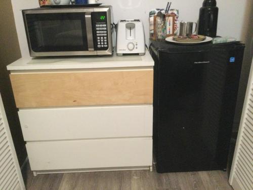 a microwave sitting on top of a counter with a refrigerator at A Gem Downtown Montreal in Montréal