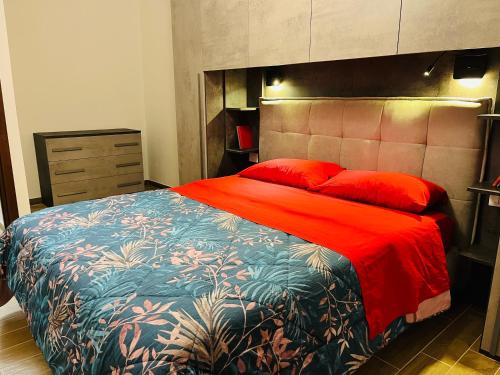 a bedroom with a large bed with red pillows at Sa domo de ziu Pedru in Sennori