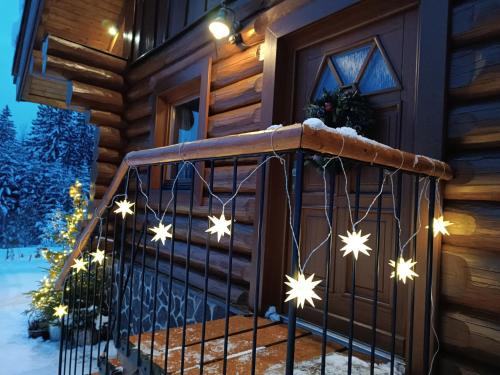 a house with christmas lights on the stairs at Srub Javorná - apartmány Šumava in Javorná