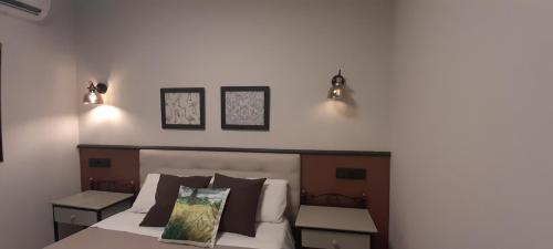 a bedroom with a bed with two lights on the wall at Hostal El Lechuguero in Cascante