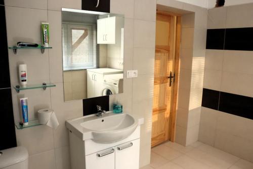 a white bathroom with a sink and a mirror at Porąbka - nocleg w urokliwym miejscu in Porąbka