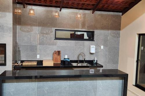eine Küche mit einem Waschbecken und einem Spiegel in der Unterkunft Casa do Lago 