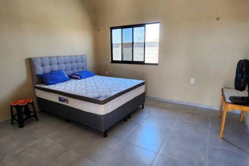 ein Schlafzimmer mit einem Bett mit blauen Kissen und einem Fenster in der Unterkunft Casa do Lago 