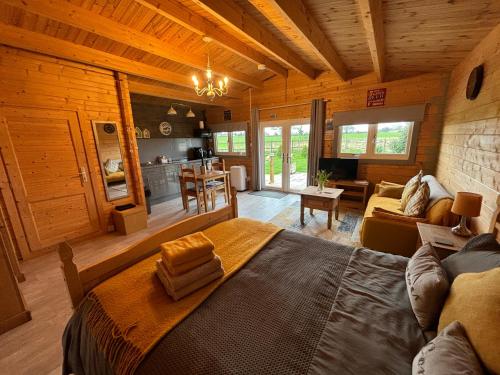 sypialnia z dużym łóżkiem w drewnianym domku w obiekcie Rife Lodges w mieście Arundel