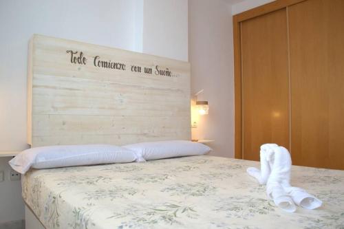 Una cama con dos toallas blancas encima. en Domus Aura, en Nerja
