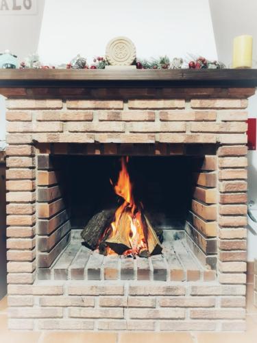 a brick fireplace with a fire in it at El Jándalo in Benaocaz