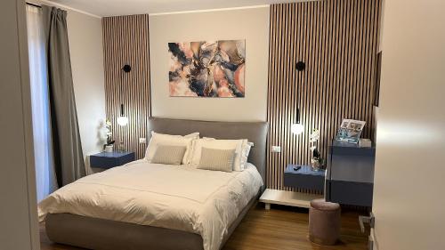 um quarto com uma cama e um quadro na parede em The Captain's Apartments Marina - next to Verbella - Leonardo Academy, MXP em Sesto Calende
