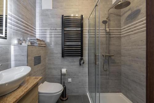 a bathroom with a shower and a toilet and a sink at Solaris Apartment Nala in Darłowo