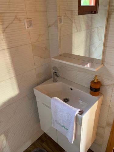 un bagno con un lavandino e un asciugamano bianco di Brvnara Emilija a Laktaši