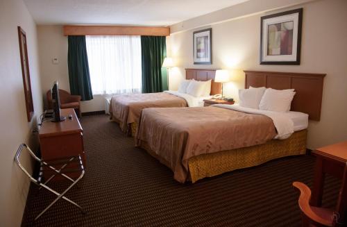 Westlock的住宿－All Stay Suites，酒店客房设有两张床和电视。