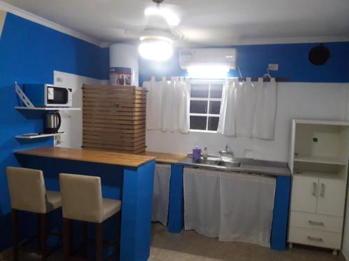 a kitchen with blue walls and a wooden counter top at Hospedaje Del Centro in Paso de los Libres