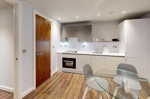 a kitchen with a glass table and chairs in it at Entire 1 bd aprt in Jewellery Q. in Birmingham