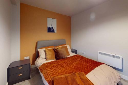 a bedroom with a large bed with an orange blanket at Entire 1 bd aprt in Jewellery Q. in Birmingham