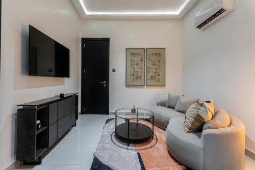 uma sala de estar com um sofá e uma televisão de ecrã plano em DLUXE PREMIUM HOTEL em Port Harcourt