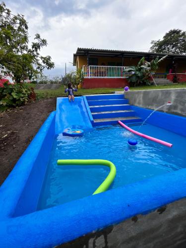 un tobogán de agua con un niño jugando en él en Yellow House, en Quimbaya