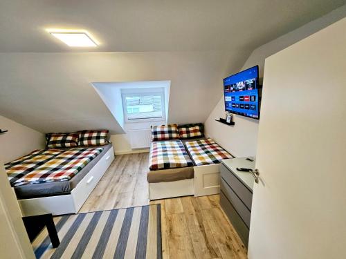 a bedroom with two beds and a flat screen tv at Pohl Fewo in Remscheid