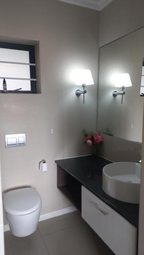 a bathroom with a toilet and a sink and a mirror at 2 bedroom morden apartment in Fairview