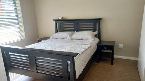a bedroom with a large bed with a wooden headboard at 2 bedroom morden apartment in Fairview