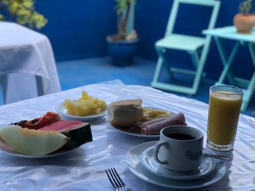 a table with two plates of food and a cup of coffee at Pousada Biribiri in Salvador