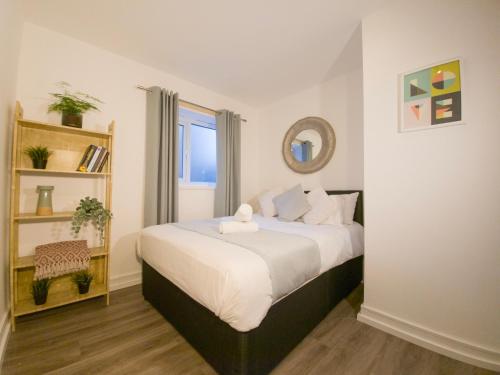 a bedroom with a large bed with a mirror at Plenty of Parking Available; 3 Bedroom Apartment by Property Promise in Cardiff