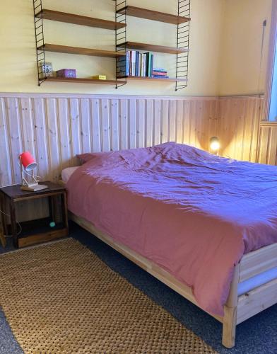 a bedroom with a bed and a table with a lamp at Fristad Nature House in Torsby