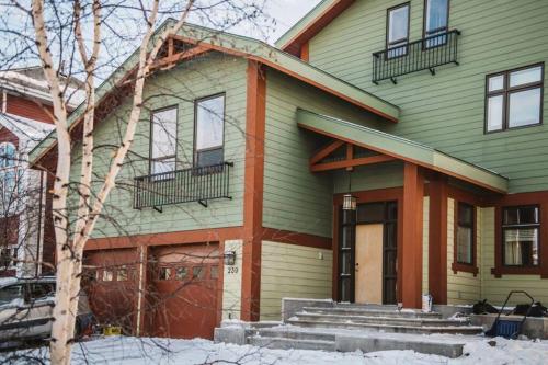 a green and orange house with snow in front of it at The Niven Lake Retreat in Yellowknife